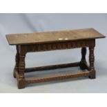A 17th AND LATER OAK DOUBLE STOOL, THE FLUTE BANDED APRON ABOVE BALUSTER TURNED LEGS JOINED BY