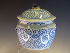 A CHINESE BLUE AND WHITE ROUNDED CYLINDRICAL JAR AND COVER PAINTED WITH LOTUS AND SCROLLED BARBED