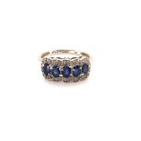 A 9ct WHITE GOLD HALLMARKED FIVE STONE SAPPHIRE RING WITH DIAMOND CLUSTERS. FINGER SIZE N. WEIGHT