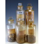 SIX CLEAR GLASS PHARMACY JARS AND STOPPERS, THE CYLINDRICAL BODIES BEARING LABELS FOR: CINNAMON,