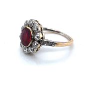 AN ANTIQUE RUBY AND DIAMOND OVAL CLUSTER RING. THE OVAL RUBY SURROUNDED BY TEN OLD CUT DIAMONDS UPON