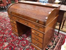 AN EDWARDIAN LINE INLAID MAHOGANY ROLL TOP PEDESTAL DESK, THE SLATTED TOP ABOVE THREE DRAWERS, A