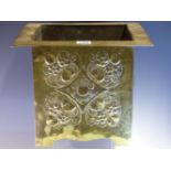 AN ARTS AND CRAFTS BRASS PLANTER, THE FLAT RIM OVER BOSSES ON TWO OF THE SQUARE SIDES AND A FLOWER