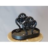 A VICTORIAN IRON BOOT SCRAPER ON TREFOIL TOPPED SUPPORTS CAST WITH ROSETTES AND ENDING IN PAWS