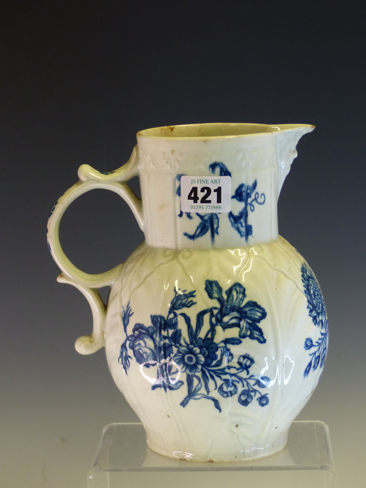 AN 18th C. WORCESTER BLUE AND WHITE MASK JUG PRINTED WITH ROSES AND OTHER FLOWER IN SPRAYS, CRESCENT