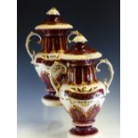 A PAIR OF POTTERY TWO HANDLED BALUSTER JARS AND COVERS LABELLED HEMLOCK AND CLOVES IN GILT ON A WINE