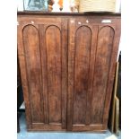 A LATE 19th/EARLY 20th C. OAK WARDROBE, EACH DOOR MADE OF TWO ROUND ARCHED PANELS AND ABOVE THE