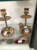 A PAIR OF DOULTON STONE WARE CANDLESTICKS WITH RING HANDLED BASES TOGETHER WITH A RED GLASS DOUBLE