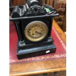 A BLACK SLATE CASED CLOCK STRIKING ON A COILDED ROD