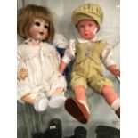 A KAMMER AND REINHARDT 22 BISQUE HEADED DOLL TOGETHER WITH A PLASTIC DOLL