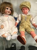 A KAMMER AND REINHARDT 22 BISQUE HEADED DOLL TOGETHER WITH A PLASTIC DOLL