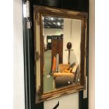 A DECORATIVE BEVELLED EDGE MIRROR. 112 x 81cms