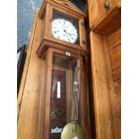 A GLAZED PINE CASED KIENINGER THREE TRAIN WALL CLOCK