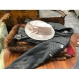 A BLACK LEATHER MOTORBIKE JACKET TOGETHER WITH A FUR RUG AND A LADYS HAT