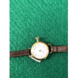 A 14ct GOLD VINTAGE LADIES WALTHAM WRIST WATCH ON A LEATHER STRAP.