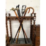 A VICTORIAN OAK STICK STAND WITH WALKING STICKS AND A SHOOTING STICK