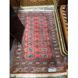 AN AFGHAN RUG. 208 x 110cms TOGETHER WITH AN ORIENTAL RUG OF BOKHARA DESIGN (2)