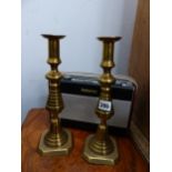 A PAIR OF BRASS CANDLESTICKS AND A VINTAGE RADIO.