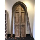 A PAIR OF PANELLED ARCH TOP DOORS COMPLETE WITH SURROUND