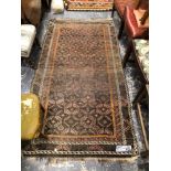 AN ANTIQUE BELOUCH RUG. 207 x 111cms TOGETHER WITH A FLUFFY BLACK RUG (2)