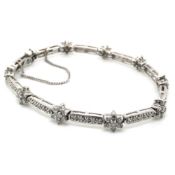 A 14ct WHITE GOLD HALLMARKED CLUSTER AND PANEL DIAMOND LINE BRACELET COMPLETE WITH SAFETY CHAIN.