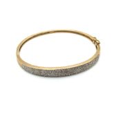 A DIAMOND HINGED BANGLE. UNHALLMARKED, ASSESSED AS 9ct GOLD. WEIGHT 11.38grms.