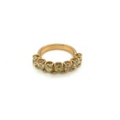 A SEVEN STONE YELLOW DIAMOND HALF ETERNITY RING. UNHALLMARKED, STAMPED 750, ASSESSED AS 18ct GOLD.