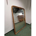 A VICTORIAN RECTANGULAR MIRROR WITH A ROUNDED TOP AND WITHIN A BEADED AND FOLIATE GILT FRAME CRESTED