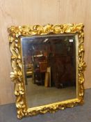 AN ITALIAN BEVELLED GLASS RECTANGULAR MIRROR IN A GILT WOOD FRAME CARVED WITH ANTHEMION MOTIFS AND