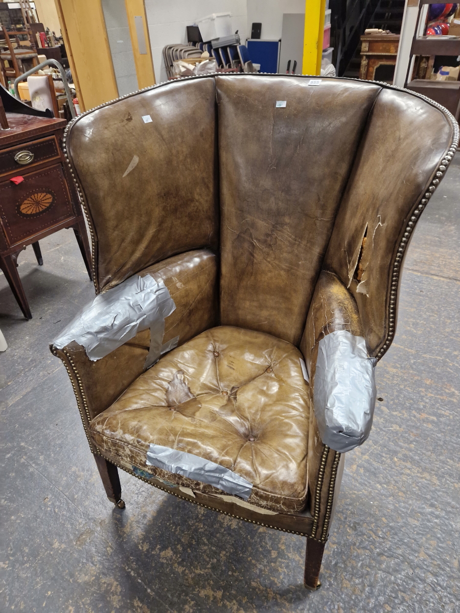 AN ANTIQUE LEATHER UPHOLSTERED WING ARMCHAIR WITH THE BACK ROUNDING OVER THE ARMS, THE SQUARE - Image 2 of 5