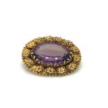 AN ANTIQUE AMETHYST OVAL FILIGREE BROOCH, ENGRAVED INDISTINCTLY WITH TWO NAMES VERSO. LENGTH 3.0cms.