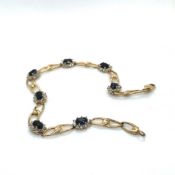 A 9ct HALLMARKED GOLD, SAPPHIRE AND DIAMOND MULTI CLUSTER LINE BRACELET. LENGTH 18cms. WEIGHT 5.