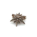 AN ANTIQUE DIAMOND CELESTIAL STAR BROOCH. APPROX DIAMETER 2.2cms. UNHALLMARKED, ASSESSED AS 9ct GOLD