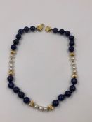 A ROW OF LAPIS, PEARL AND GOLD BEADS. THE BOW CLASP STAMPED D925, THE BEADS ASSESSED AS 14ct. LENGTH