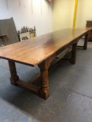 A 17th C. STYLE OAK REFECTORY TABLE, THE THREE PLANK TOP ABOVE A FLUTED APRON AND SIX CYLINDRICAL LE