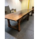 A 17th C. STYLE OAK REFECTORY TABLE, THE THREE PLANK TOP ABOVE A FLUTED APRON AND SIX CYLINDRICAL LE