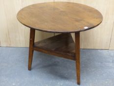 AN OAK CRICKET TABLE, THE CIRCULAR TOP ABOVE A TRIANGULAR TIER JOINING THE THREE LEGS. Dia. 88 x H