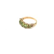 A FIVE STONE PERIDOT GRADUATED CARVED HALF HOOP RING. UNHALLMARKED, STAMPED 9ct, ASSESSED AS 9ct