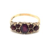 A 9ct HALLMARKED GOLD SEVEN STONE GARNET CARVED HALF HOOP RING. FINGER SIZE R 1/2. WEIGHT 2.90grms.