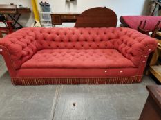 A VINTAGE CHESTERFIELD BUTTON UPHOLSTERED IN RED. W 241 x D 95 x H 78cms.