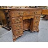 A GEORGE III CROSS BANDED WALNUT KNEEHOLE DESK, A SINGLE LONG DRAWER ABOVE BANKS OF THREE AND SHAPED