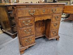 A GEORGE III CROSS BANDED WALNUT KNEEHOLE DESK, A SINGLE LONG DRAWER ABOVE BANKS OF THREE AND SHAPED