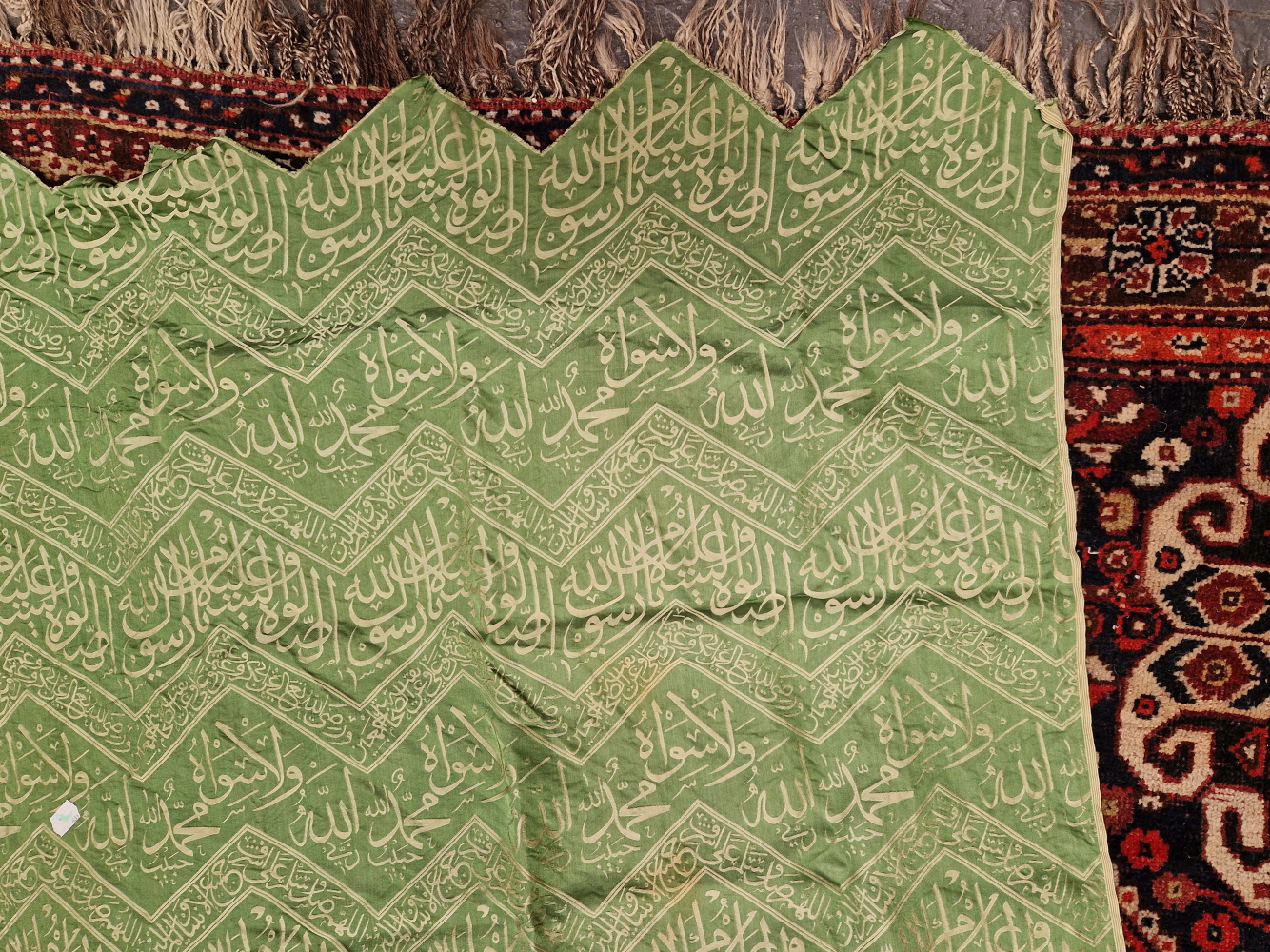 AN ISLAMIC GREEN SILK PANEL WOVEN IN SILVERY GREY WITH CHEVRON BANDS OF SCRIPT. 148 x 84cms. - Image 2 of 6