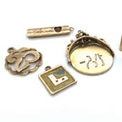 FIVE VARIOUS 9ct GOLD CHARMS TO INCLUDE A £1 NOTE IN EMERGENCY BRAK GLASS, AN I LOVE YOU SPINNER,