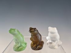THREE LALIQUE GLASS FROGS IN CLEAR, GREEN AND AUBERGINE COLOURS, INCISED LALIQUE FRANCE. H 5.5cms.