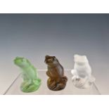 THREE LALIQUE GLASS FROGS IN CLEAR, GREEN AND AUBERGINE COLOURS, INCISED LALIQUE FRANCE. H 5.5cms.