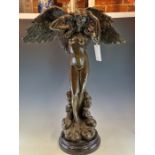 A COLD CAST BRONZE FIGURE OF AN ANGEL STANDING ON STYLISED CLOUDS WITH HER HANDS ON HER HEAD AND HER