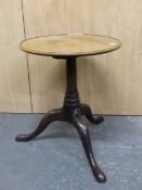 A GEORGE III AND LATER MAHOGANY TRIPOD TABLE,THE DISHED CIRCULAR TOP ON A GUN BARREL COLUMN RING