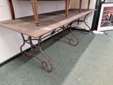 A RECTANGULAR WEATHERED STEEL REFECTORY TABLE, THE WROUGHT IRON LEGS TO EACH NARROW END ON PAIRS OF