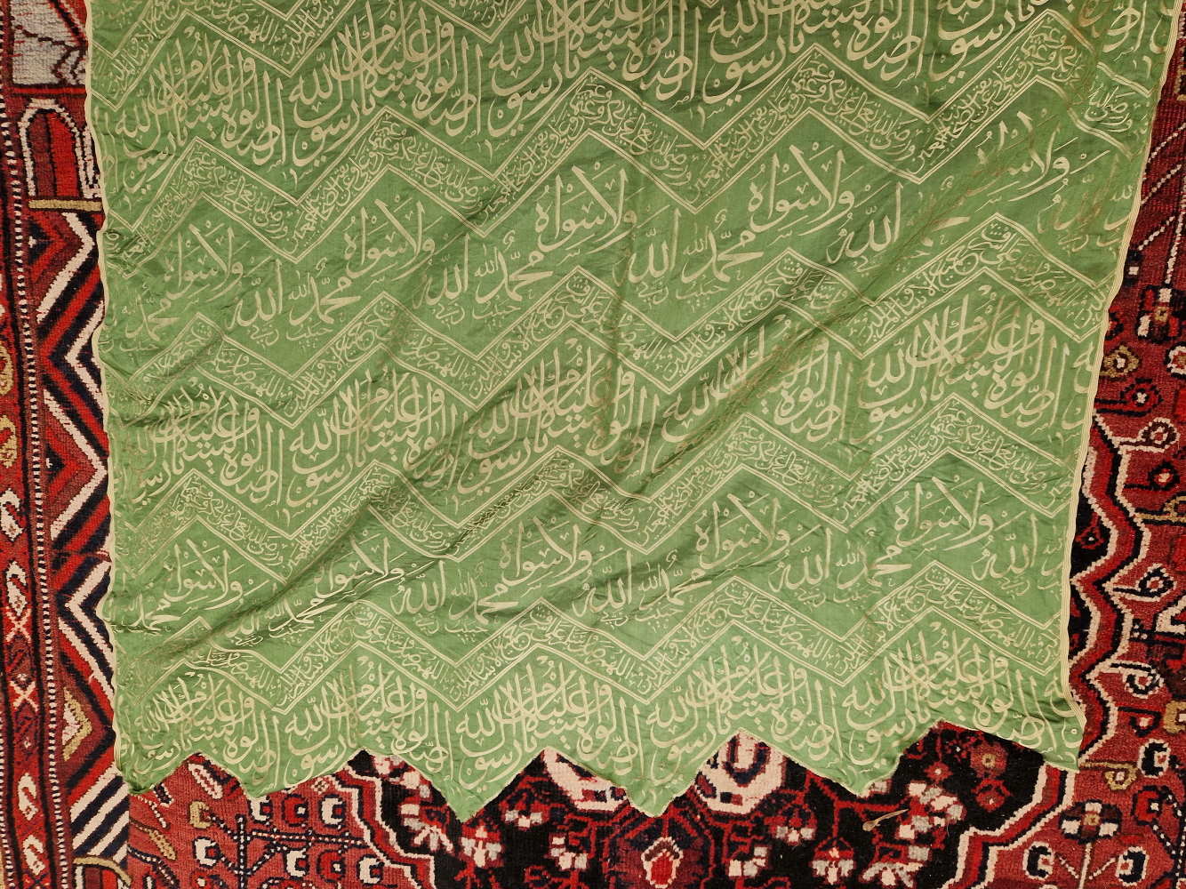 AN ISLAMIC GREEN SILK PANEL WOVEN IN SILVERY GREY WITH CHEVRON BANDS OF SCRIPT. 148 x 84cms. - Image 5 of 6